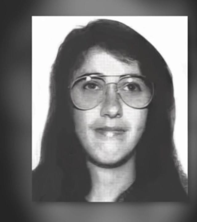 Schwarz-weißes Porträtfoto einer Person mit langen dunklen Haaren und großer runder Brille. Die Person blickt frontal in die Kamera. Das Bild zeigt Kopf und oberen Schulterbereich vor einem hellen Hintergrund. Oben rechts steht der Text „Foto: Polizei Koblenz“.