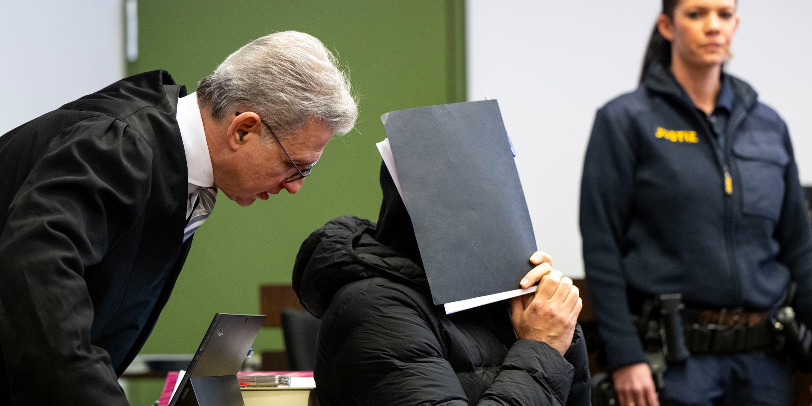 Archiv: Der wegen sexuellen Missbrauchs angeklagte Fußballtrainer (M) unterhält sich zum Prozessauftakt im Gerichtssaal des Landgerichts mit seinem Rechtsanwalt Peter Guttmann.