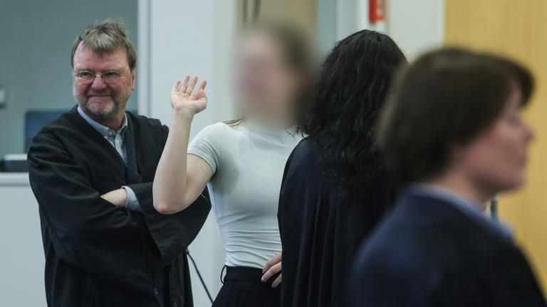 Nordrhein-Westfalen, Düsseldorf: Eine Angeklagte (2.v.l.) winkt im Sitzungssaal im Oberlandesgericht in Düsseldor zu den Zuschauern.