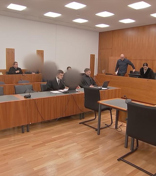 Menschen sitzen im Gerichtssaal
