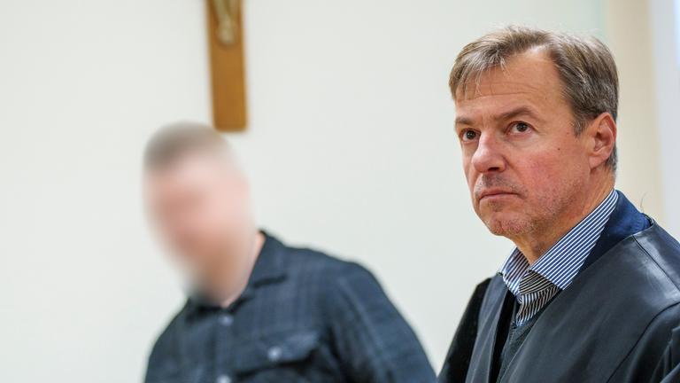 27.10.2025, Bayern, Alzenau: Der angeklagte Polizist (l) und Frank Kumpolt, Anwalt des Angeklagten, haben sich im Gerichtssaal erhoben.