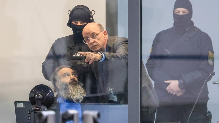 Der Angeklagte Taleb al-Abdulmohsen spricht mit einem Dolmetscher zu Prozessbeginn in einem kugelsicheren Glaskasten im Gerichtssaal im temporären Gerichtsgebäude des Landgerichtes Magdeburg.