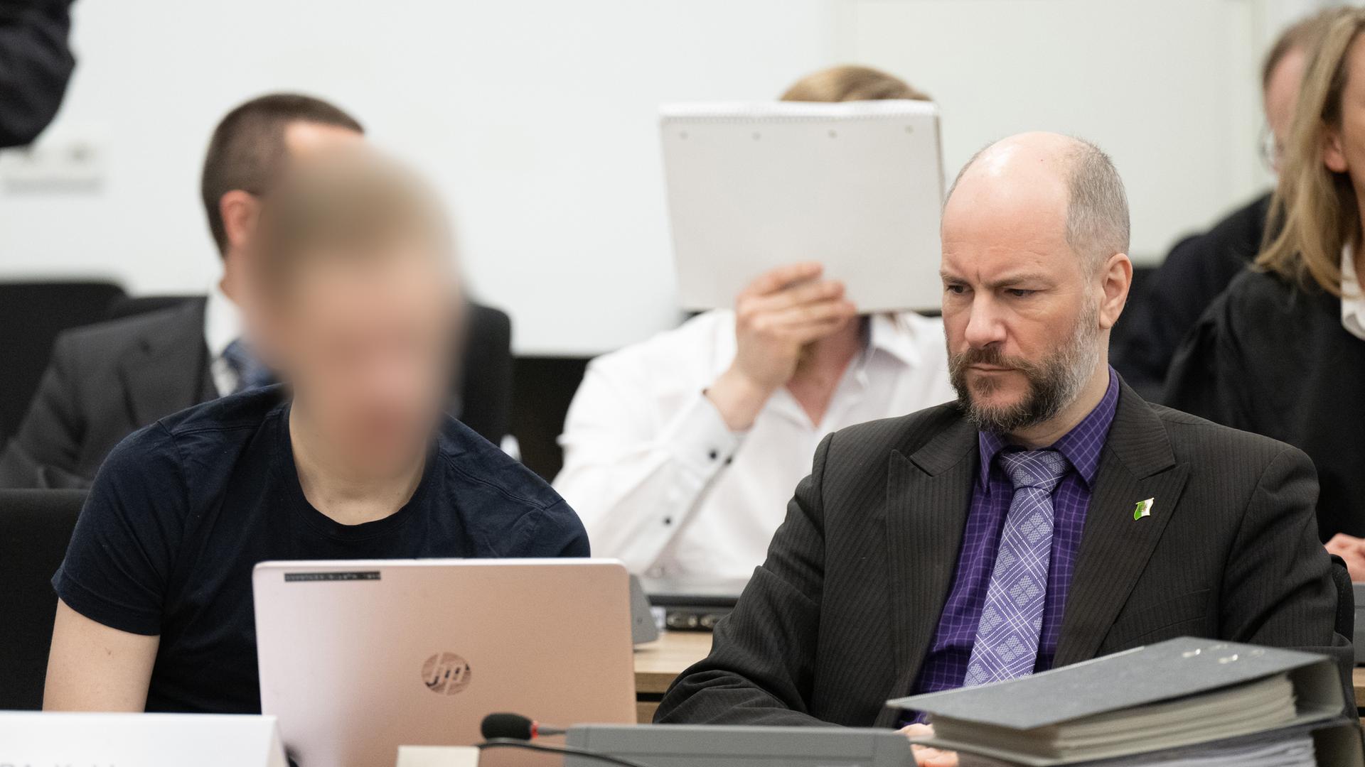 Ein Angeklagter im Prozess gegen insgesamt acht mutmaßlich militante Neonazis sitzt im Oberlandesgericht neben Martin Kohlmann (r), Rechtsanwalt. 