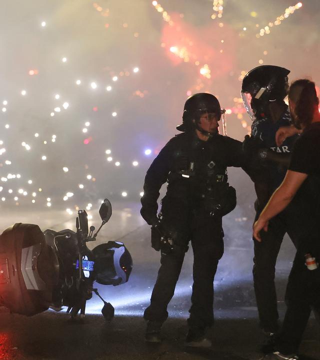 Die Polizei versucht, PSG-Anhänger zu zerstreuen, die am Samstag, dem 30. Mai 2026, nach dem Finale der Champions League in Paris feiernd Feuerwerk zündeten.