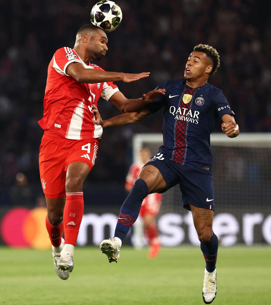 Bayern Münchens Jonathan Tah kommt vor Desire Doue zum Kopfball