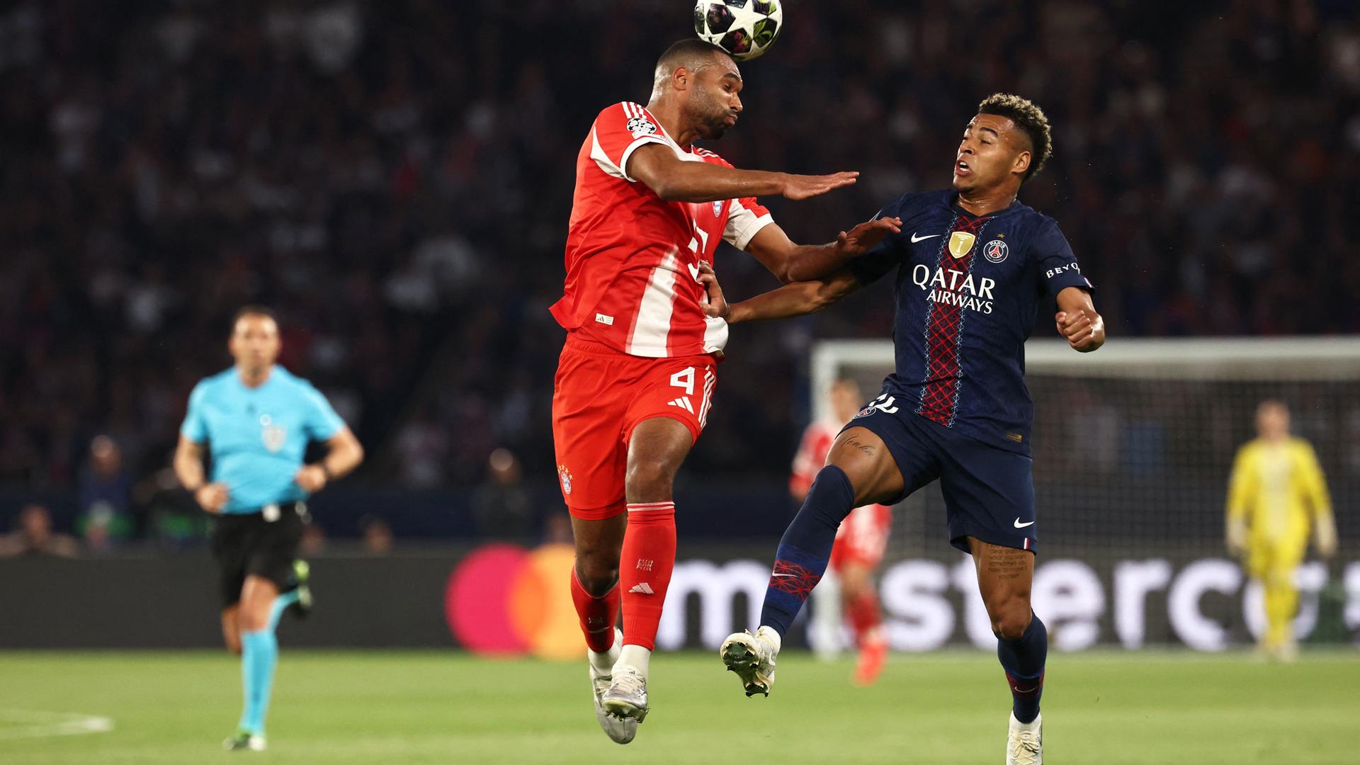 Bayern Münchens Jonathan Tah kommt vor Desire Doue zum Kopfball