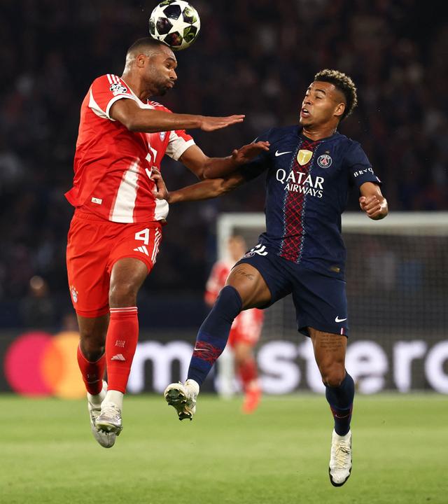 Bayern Münchens Jonathan Tah kommt vor Desire Doue zum Kopfball