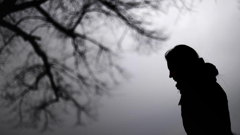 Eine Frau steht neben einem Baum.