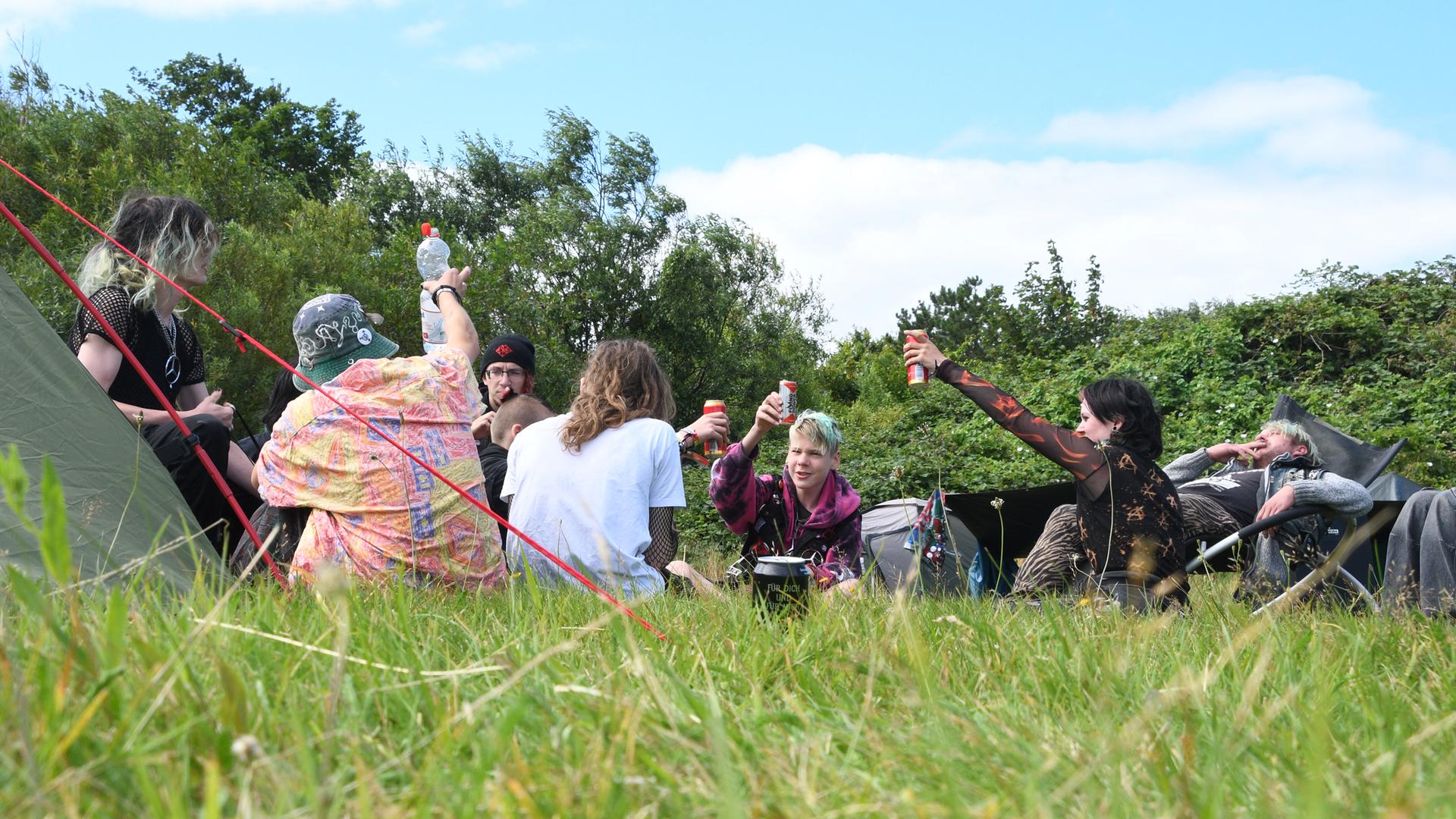 Schleswig-Holstein, Tinnum: Teilnehmer des Punk-Protestcamps auf Sylt sitzen auf der Camp-Wiese von "Aktion Sylt".