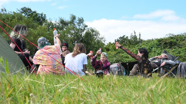 Schleswig-Holstein, Tinnum: Teilnehmer des Punk-Protestcamps auf Sylt sitzen auf der Camp-Wiese von "Aktion Sylt".