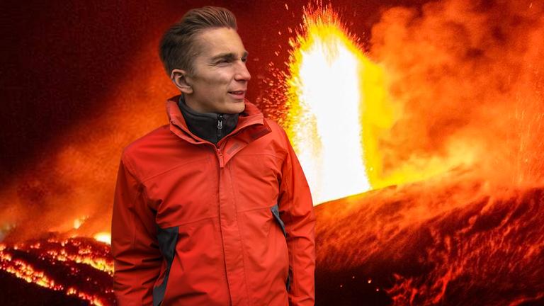 Eric steht vor einem ausbrechenden Vulkan, es spritzt Feuer in einer Fontäne nach oben (Collage).