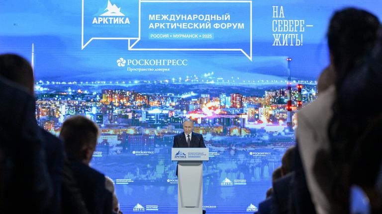 Putin steht auf einer Bühne und hält eine Rede auf dem 6. Internationalen Arktisforum.