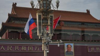 Eine russische und eine chinesische Fahne wehen am Tor des Himmlischen Friedens