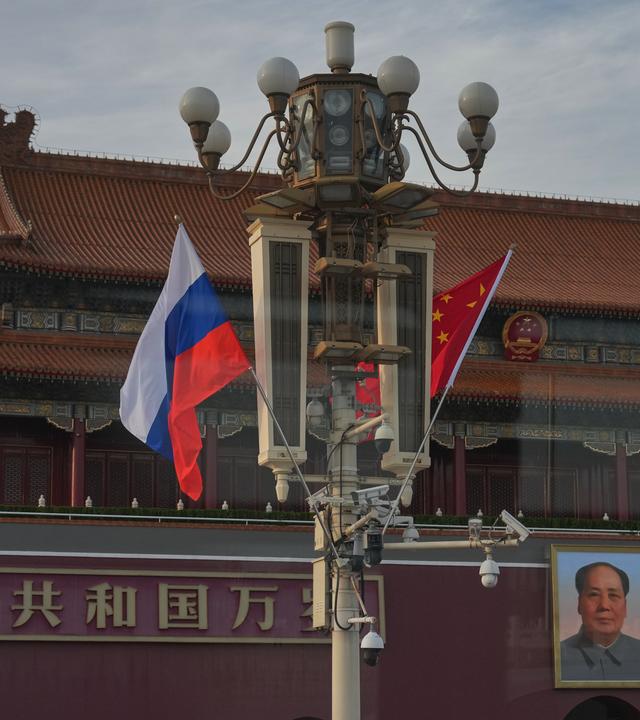 Eine russische und eine chinesische Fahne wehen am Tor des Himmlischen Friedens