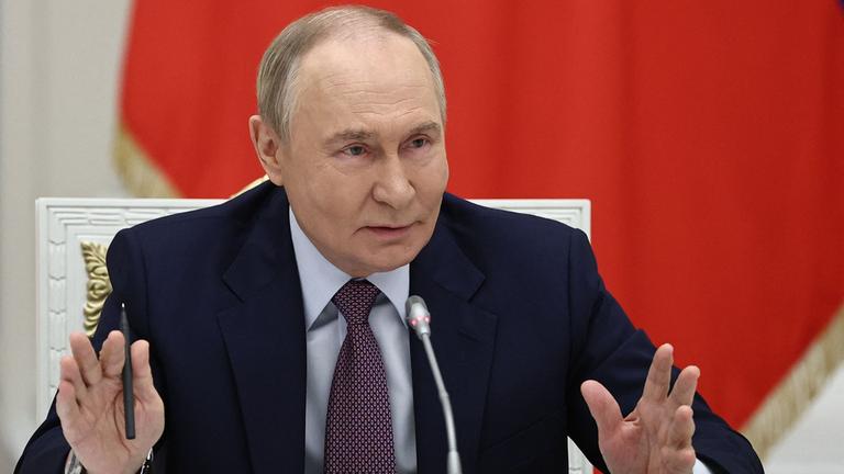 Putin hält vor einer russlandflagge eine Rede