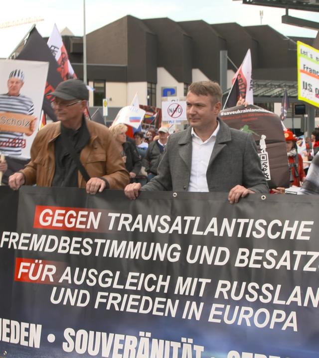 Anhänger und Mitglieder der Partei "Aufbruch Frieden-Souveränität-Gerechtigkeit" mit transparent auf einer Demo 