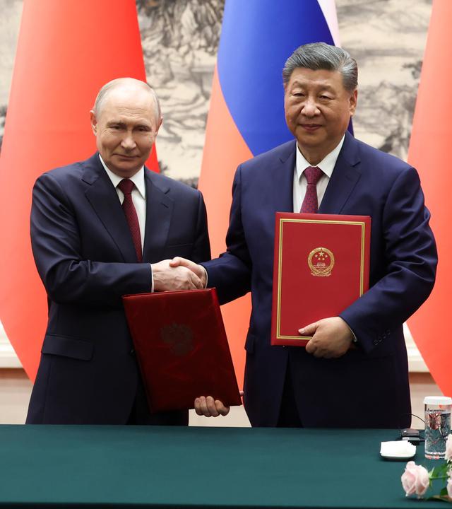 China, Peking: Der russische Präsident Wladimir Putin, links, und der chinesische Präsident Xi Jinping geben sich während einer Unterzeichnungszeremonie in der Großen Halle des Volkes die Hand