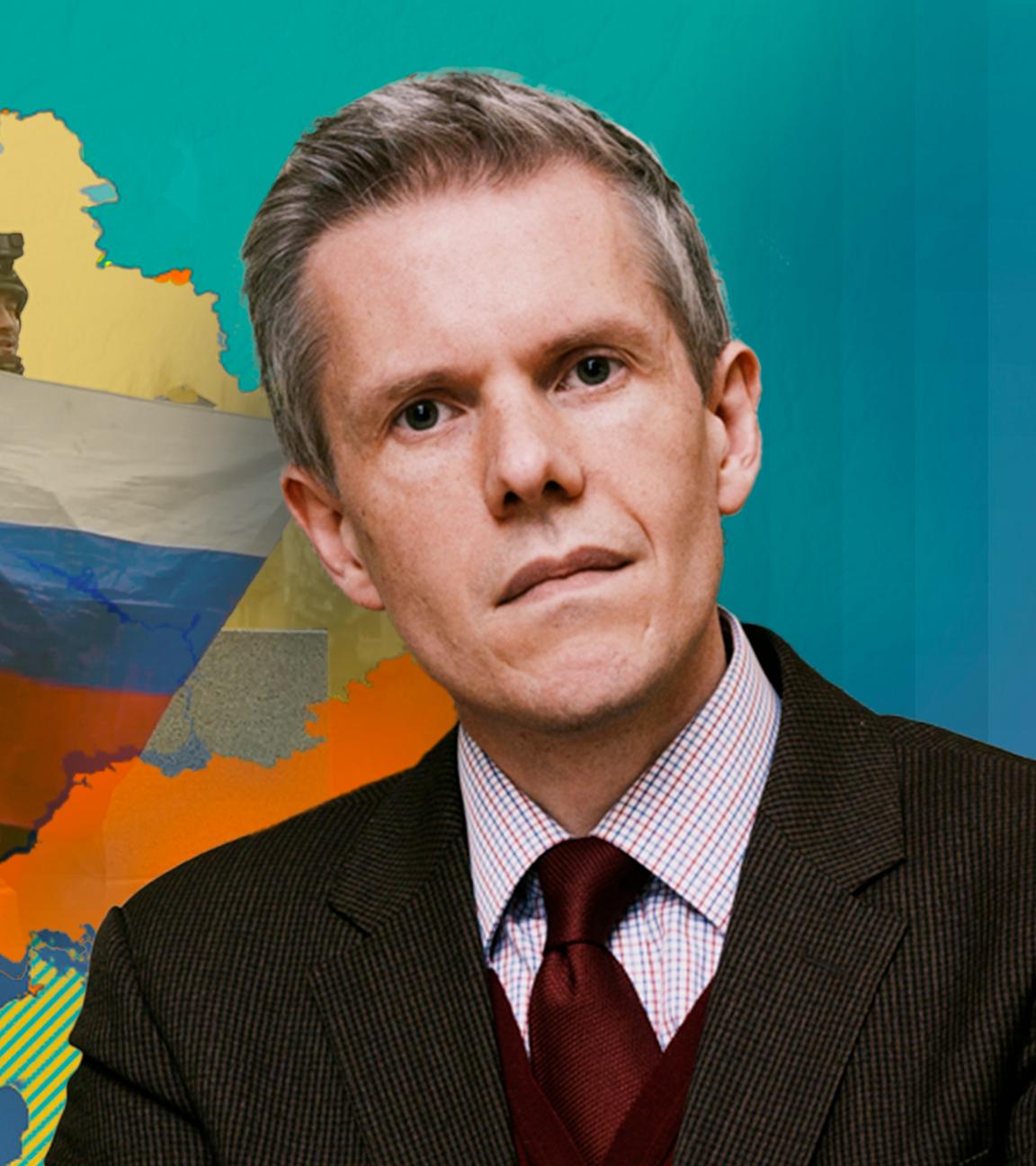 Dr. Marcus M. Keupp vor einer Karte der Ukraine mit Russischer Flagge im Hintergrund.