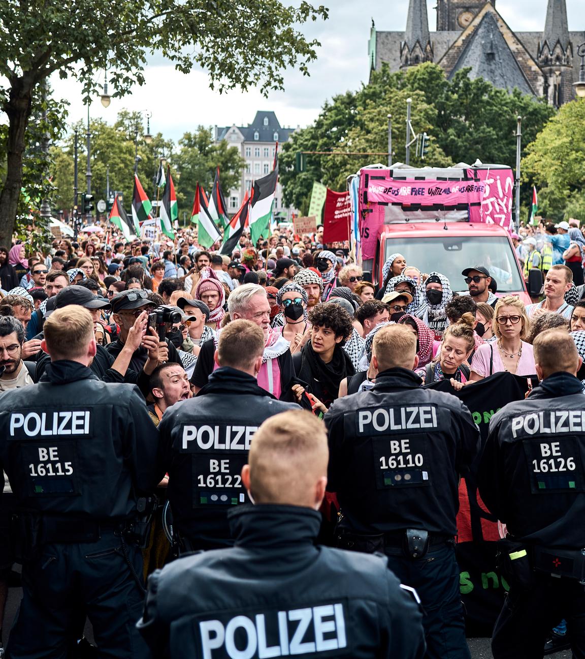 Teilnehmer der Internationalist Queer Pride for Liberation (IQP) stehen in Berlin-Kreuzberg Polizisten gegenüber.