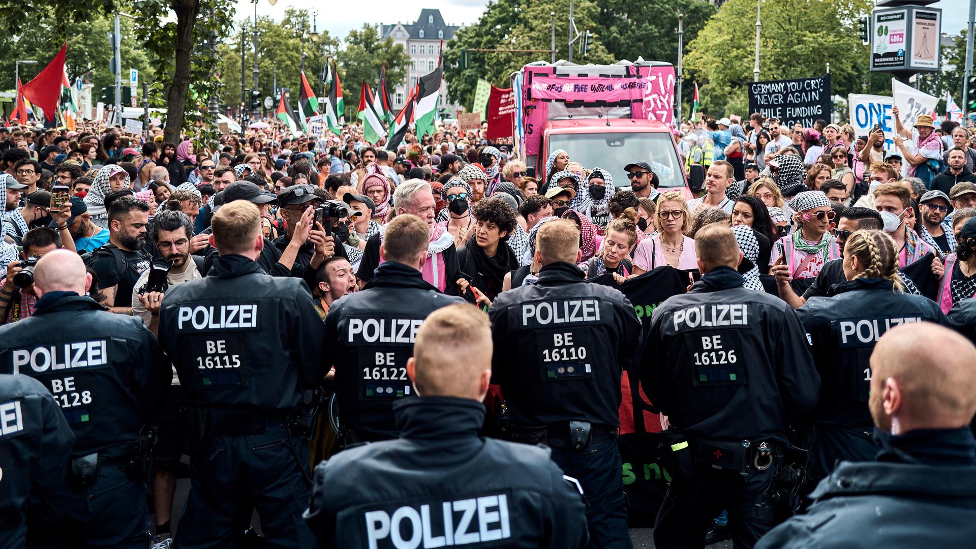 Teilnehmer der Internationalist Queer Pride for Liberation (IQP) stehen in Berlin-Kreuzberg Polizisten gegenüber.