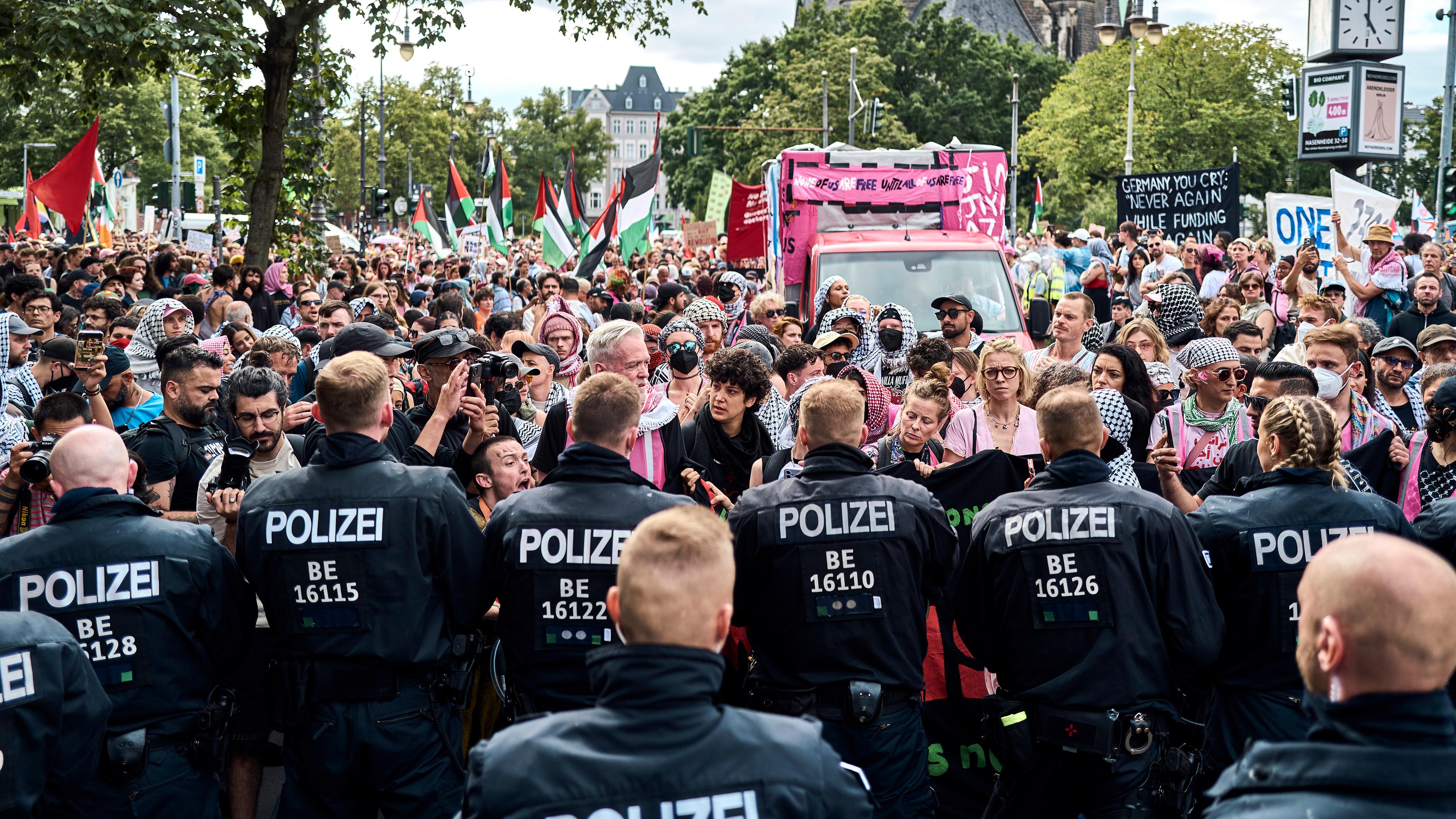 Teilnehmer der Internationalist Queer Pride for Liberation (IQP) stehen in Berlin-Kreuzberg Polizisten gegenüber.