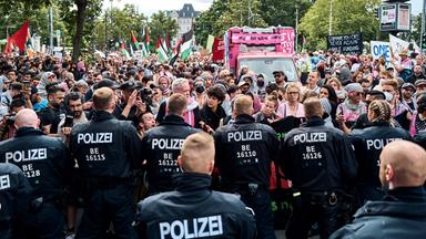 Teilnehmer der Internationalist Queer Pride for Liberation (IQP) stehen in Berlin-Kreuzberg Polizisten gegenüber.