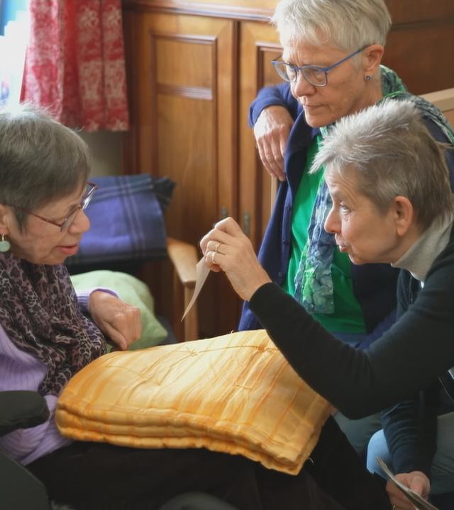 Eine Seniorin zeigt einer anderen Seniorin ein Bild