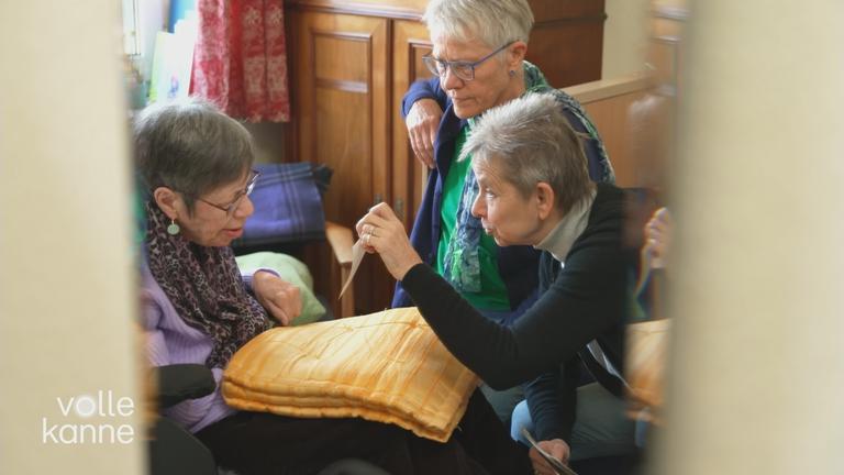 Eine Seniorin zeigt einer anderen Seniorin ein Bild