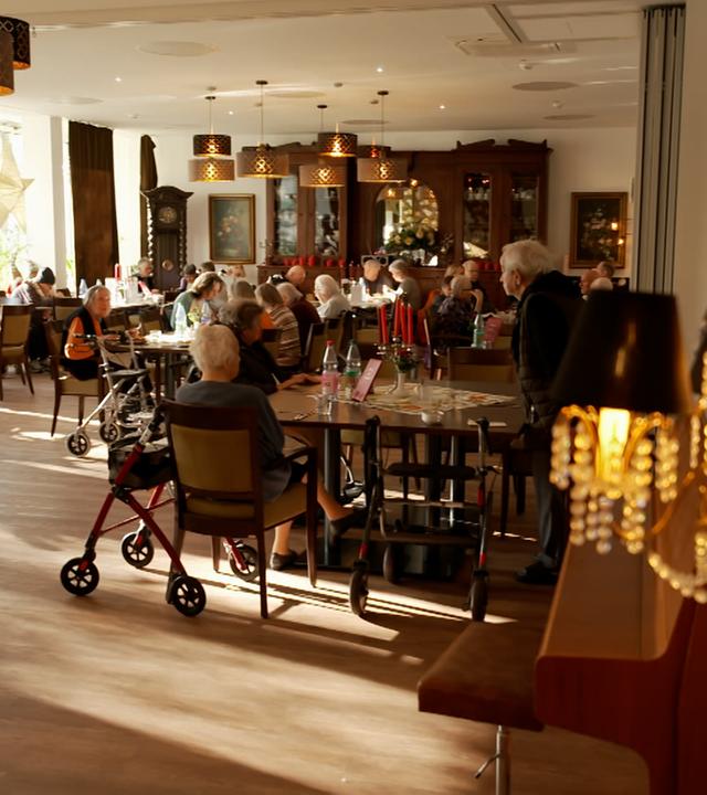 Bewohner des queeren Pflegeheims "Juli-Roger-Haus" sitzen versammelt beieinander.