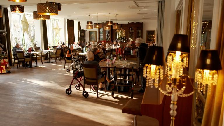 Bewohner des queeren Pflegeheims "Juli-Roger-Haus" sitzen versammelt beieinander.