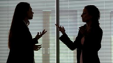 Zwei Frauen heben gestikulierend die Hände in die Höhe, während sie diskutieren.