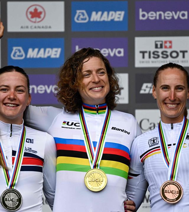 Die Zweitplatzierte Zoe Bäckstedt (Wales), die Siegerin Marlen Reusser (Schweiz) und die Drittplatzierte Franziska Koch (Deutschland) feiern auf dem Podium am 20.09.2026 in Montreal.