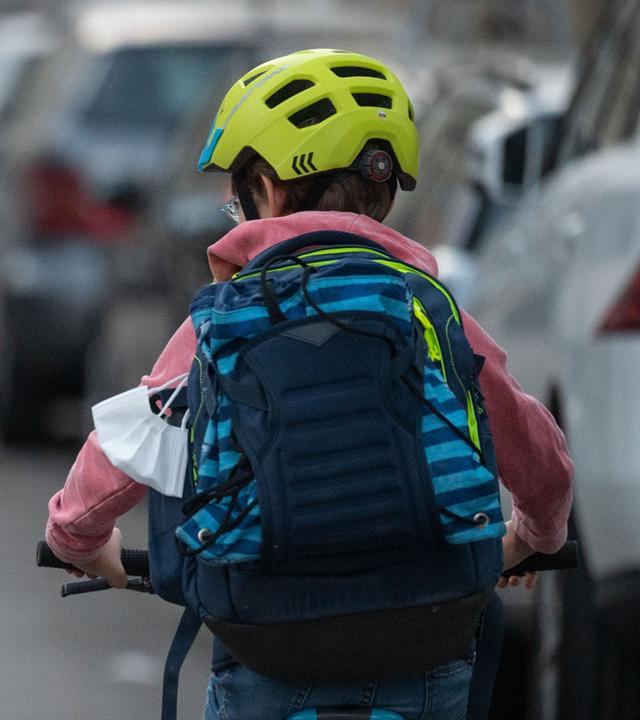 Baden-Württemberg, Stuttgart: Ein Schulkind fährt mit seinem Fahrrad eine Straße entlang.