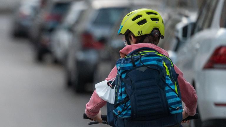 Baden-Württemberg, Stuttgart: Ein Schulkind fährt mit seinem Fahrrad eine Straße entlang.