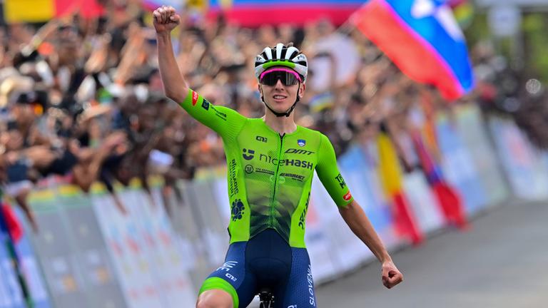 Tadej Pogacar gewinnt die Straßenweltmeisterschaften 2025 in Kigali. Er jubelt auf seinem Rad bei der Ziellinie.