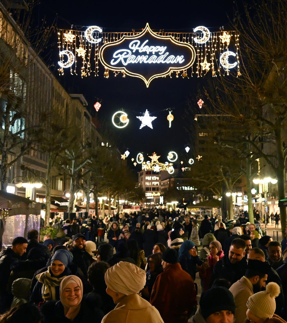 Passanten fotografieren mit ihren Handys die «Happy Ramadan» Beleuchtung in Frankfurt. Die Stadt hatte die Beleuchtung anlässlich des bevorstehenden Ramadan aufhängen lassen.