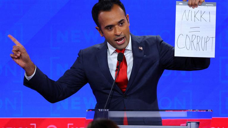 Der republikanische Präsidentschaftskandidat und Geschäftsmann Vivek Ramaswamy hält ein handgeschriebenes Schild hoch, das sich auf Mitkandidatin Nikki Haley bezieht.