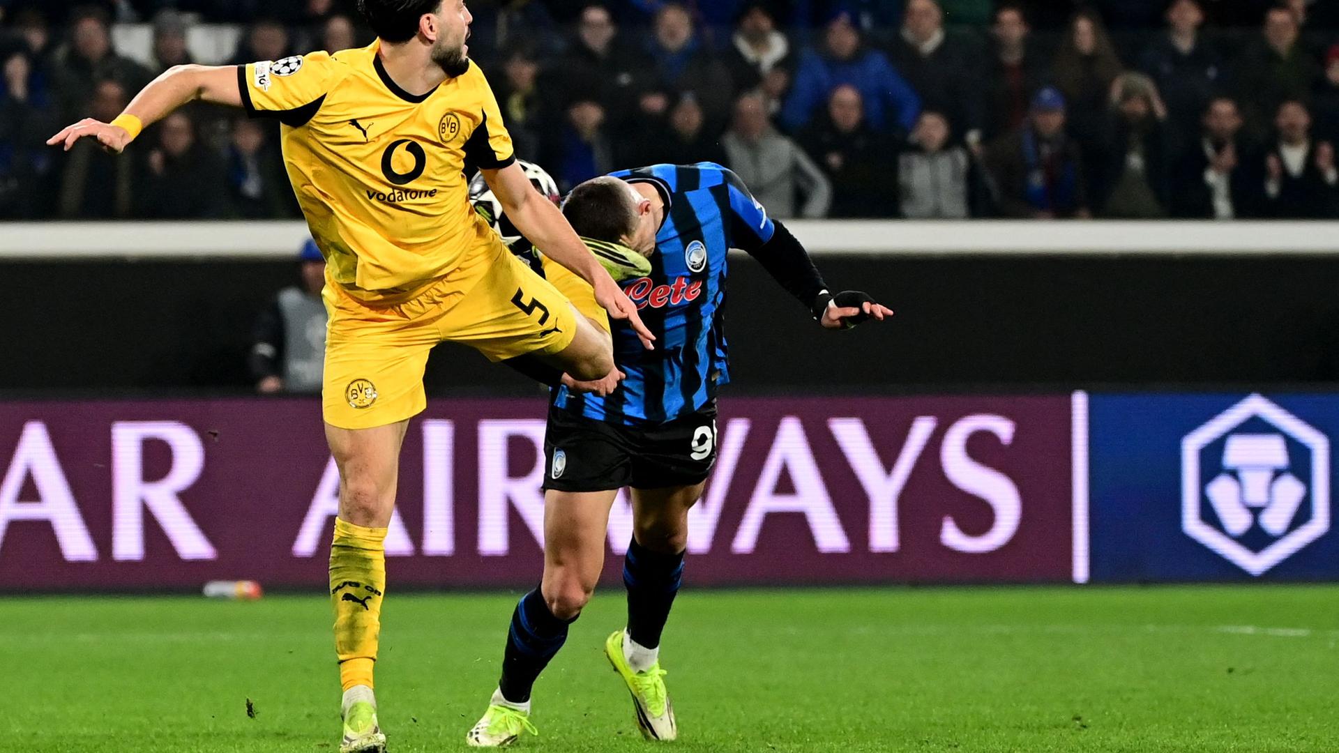 Dortmunds Verteidiger Ramy Bensebaini foult Atalantas Stürmer Nikola Krstovic am 25.02.2026 in Bergamo. 