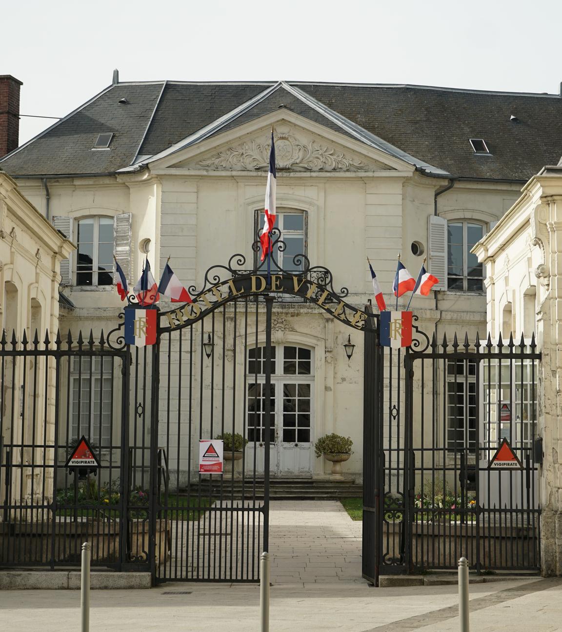 Das Rathaus der französischen Stadt Villers-Cotterêts von außen. Am Tor hängen französische Flaggen.