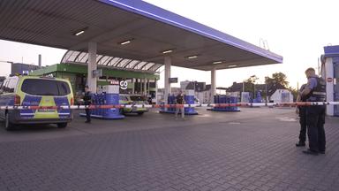 21.08.2025, Saarland, Völklingen: Polizeibeamte untersuchen den Tatort Tankstelle nach einem Raubüberfall.