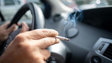 15.09.2019, Niedersachsen, Hannover: Ein Mann sitzt rauchend am Lenkrad eines Autos.