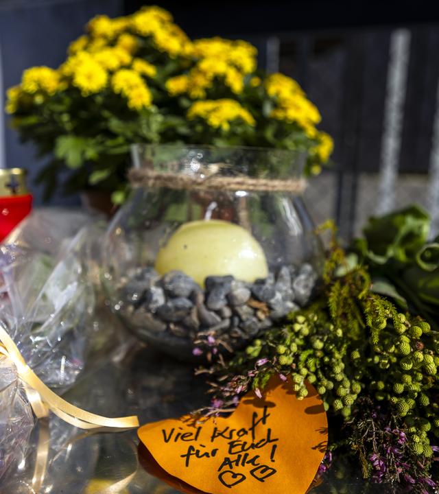 Blumen und Kerzen sowie ein Zettel mit der Aufschrift Viel Kraft für Euch Alle wurden in Aarau vor dem Eingang der Pferderennbahn Schachen, dem Ort einer Rave-Party, niedergelegt.