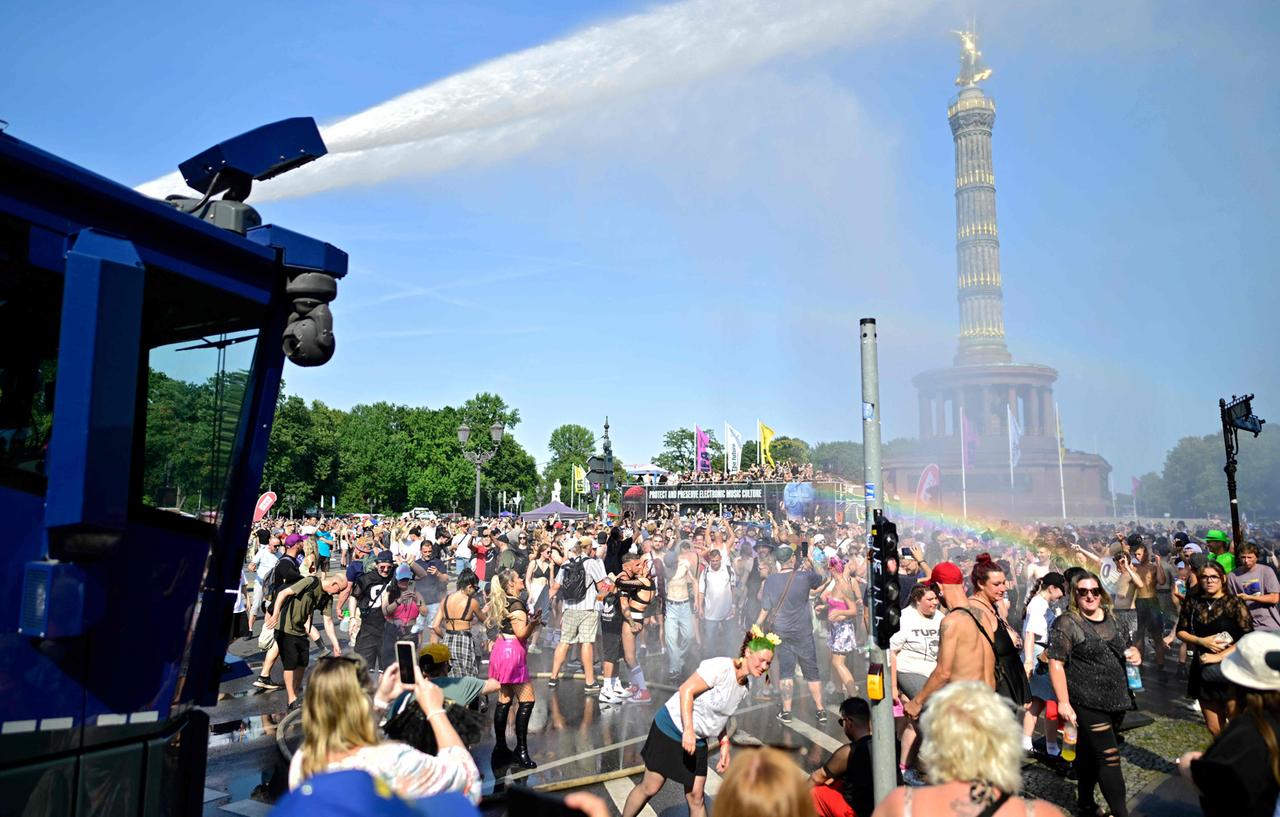 Ein Wasserwerfer der Polizei sprüht Wasser auf die Menge, um die Teilnehmer der „Rave the Planet Parade“ am 15. August 2026 in Berlin abzukühlen, wo die Temperaturen 35 Grad Celsius erreichten. 