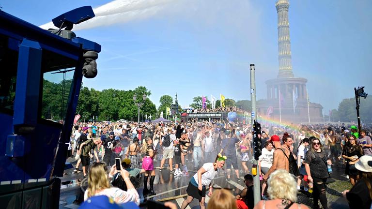 Ein Wasserwerfer der Polizei sprüht Wasser auf die Menge, um die Teilnehmer der „Rave the Planet Parade“ am 15. August 2026 in Berlin abzukühlen, wo die Temperaturen 35 Grad Celsius erreichten. 