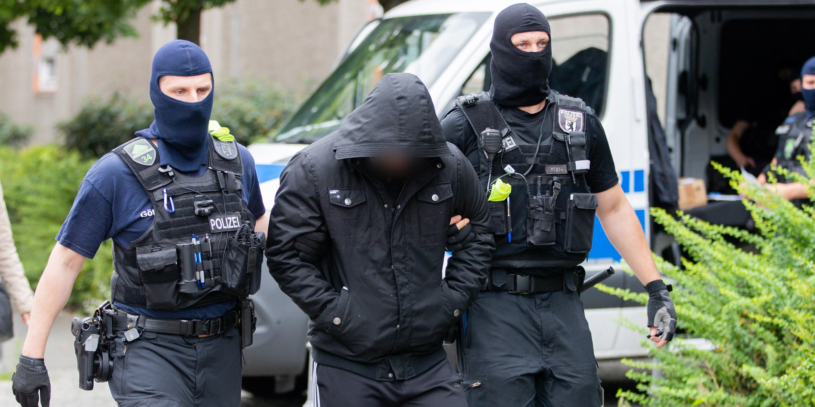Ein Mann wird bei einem Polizeieinsatz abgeführt.