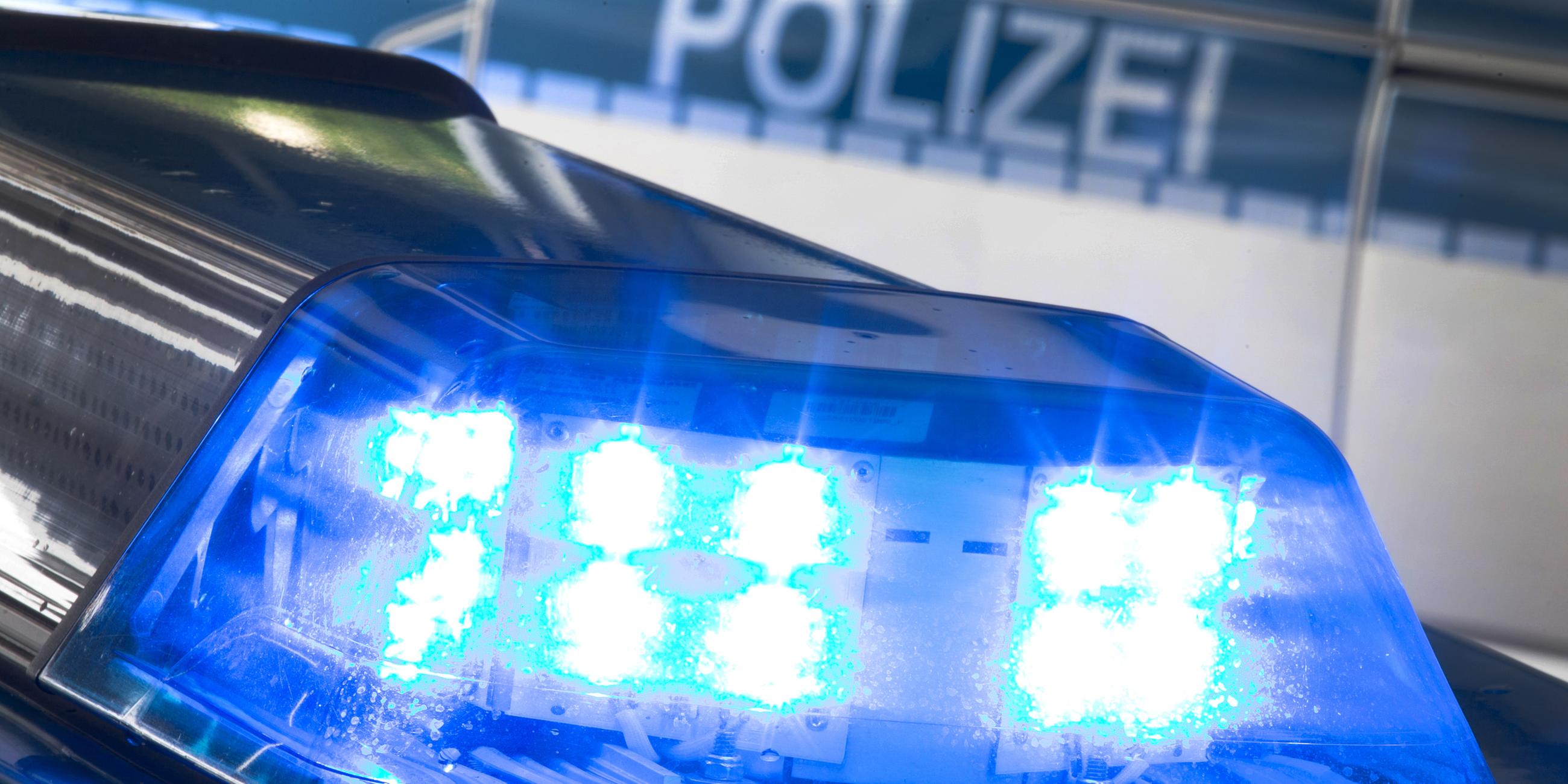 Eine Blaulicht leuchtet auf dem Dach eines Polizeiwagens.