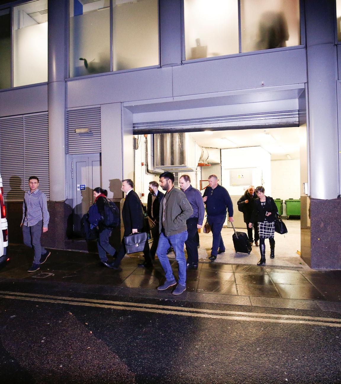 a van and a group of people leave the building which houses the offices of cambridge analytica as investigators from britain's i