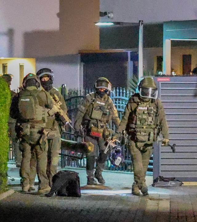  Einsatzkräfte der Polizei sind bei einer Razzia im Einsatz.