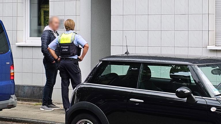 Polizei und ein Mann stehen nahe dem Einsatzort in Essen (NRW)