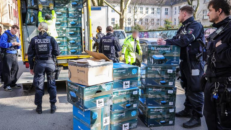 Bei einer Kontrolle gegen Sozialbetrug finden Polizeibeamte in einem Keller eines Mehrfamilienhauses über 150 originalverpackte Poolroboter, die anschließend sichergestellt werden.